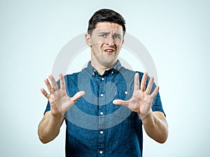 Man with scared expression on his face making frightened gesture