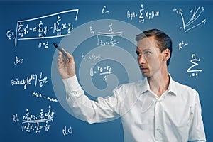 Man scientist or student working with various high school maths and science formulas.