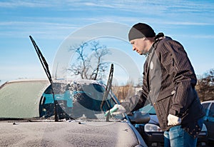 Man scraping front windshield