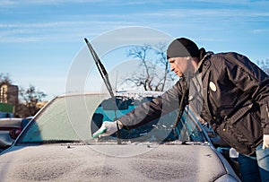Man scraping front windshield