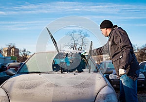 Man scraping front windshield