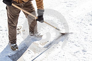 Man scraping ice with shovel