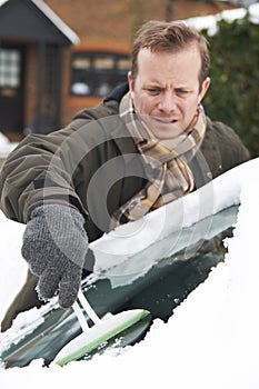 Man Scraping Snow From Car Windscreen