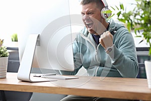 Man screaming in computer monitor sitting