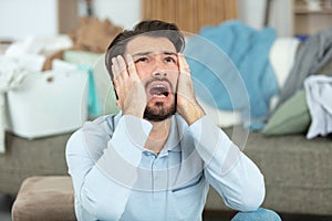 man screaming in despair surrounded by laundry