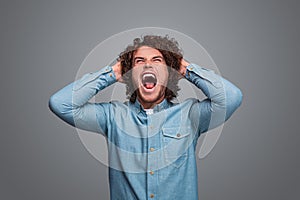 Man screaming and tearing out hair