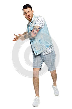 The man screams. Aggressive guy in tattoos yelling at the frame and showing his hands back