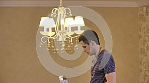 A man screwing a light bulb into a chandelier