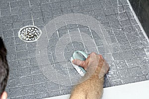 Man Scrubbing a Shower Floor