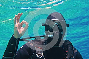 Man scuba diver underwater showing signal OK