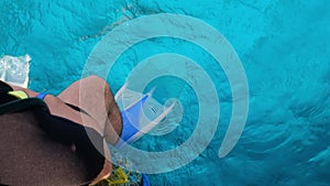 a man with scuba diving is sitting on board a yacht, preparing to dive,