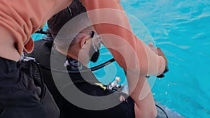 a man with scuba diving is sitting on board a yacht, preparing to dive, diving in the sea