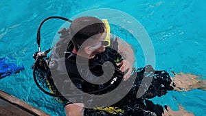 a man with scuba diving is sitting on board a yacht, preparing to dive, diving in the sea