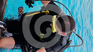 a man with scuba diving is sitting on board a yacht, preparing to dive, diving in the sea