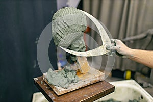 Man sculptor creates sculpt bust clay human woman sculpture. Statue craft creation workshop