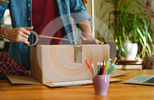 Man sealing parcel with duct tape