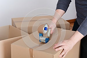 Man sealing a shipping cardboard box