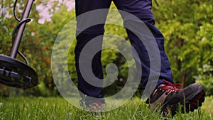 A man searches for metal with a metal detector in his garden