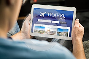 Man searching cheap flights, hotel or holiday package online photo