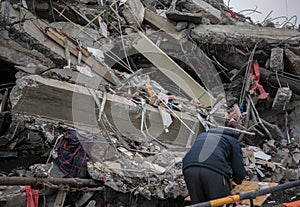 Man searching for goods in modern destroyed building ruins close