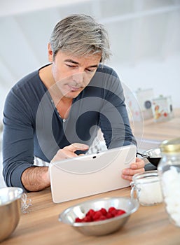 Man searching for recipe at home
