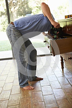 Man Searching For Something In Drawers