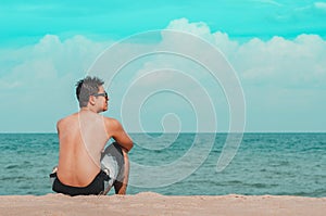 Man seated on the sand of the beach