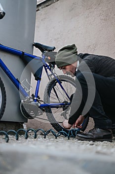 Man securing a bicycle with a lock in an urban setting