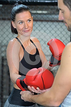 man securing boxing gloves onto woman