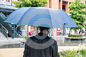 A man seeking shelter from the rain whilst out shopping