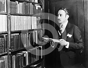 Man selecting books from bookshelf in a library