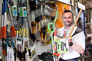 Man selecting gardening equipment in store.