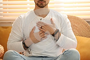 Man during self-healing session in therapy room, closeup