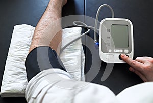 Man self-monitoring of blood pressure with a tensiometer