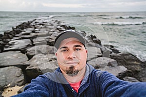 Man Self Portrait on Stone Jetty in Ocean