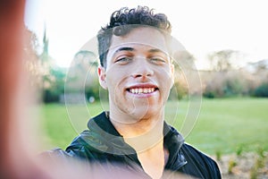 Man, selfie and smile at outdoor park in summer for walk, wellness and portrait by blurred background. Young gen z guy