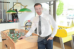 man seller standing next to fusball table photo