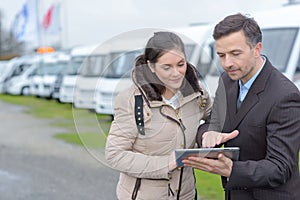 Man selling camping car to woman