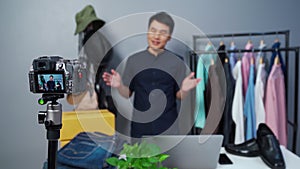 Man selling clothes and accessories online by camera live streaming, business online e-commerce at home