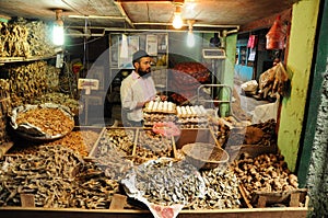 Man selling dry fish on market, India