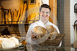 Man selling fresh pastry and baguettes in local bakery