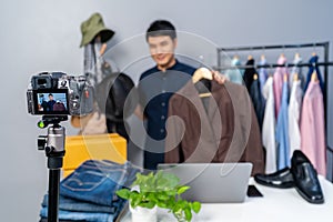 Man selling hat and clothes online by camera live streaming, business online e-commerce at home