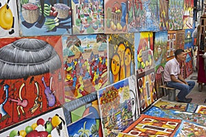 Man sells works of local artists at the street in Santo Domingo, Dominican Republic.