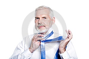 Man senior getting dressed tying windsor necktie