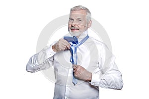 Man senior getting dressed tying windsor necktie