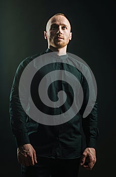 Man with serious face and brutal style. Man in a suit on a dark background. Short beard. Close up portrait of severe hot