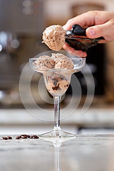 Man serving chocolate ice cream into the glass