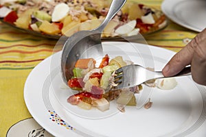 man serving mixed salad on white dish