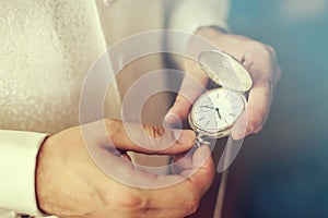 Man set a pocket watch clock in the time change vintage colored photo.