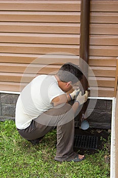 Man sets drainpipe on the wall